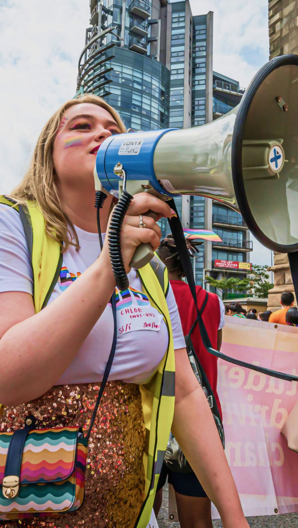 A National Union of Students volunteer in the UK rallies supporters with a bullhorn.